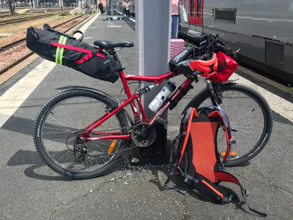 vélo équipé de sacoches et d'un sac à dos sur le quai de la gare de Poitiers